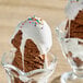 A close up of a chocolate ice cream sundae with white marshmallow topping.