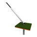 An Impact Recovery Systems driveable base for parking stops with a white and black stick on a green surface.