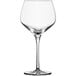 A close-up of a clear Schott Zwiesel Burgundy wine glass with a stem.