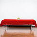 A rectangular red Intedge tablecloth on a table with a vase of flowers.