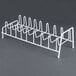 A white metal rack with eight shelves and hooks for food processor discs.