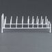 A white metal rack with eight slots for Robot Coupe food processor discs.