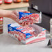 A hand holding a package of Hostess Baby Bundts with strawberry cheesecake flavored cake.