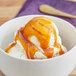 A bowl of ice cream topped with Oringer caramel sauce.