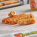 Ruiz Foods Egg, Bacon, Cheese, & Salsa Tornado Taquitos with sauce on a plate.