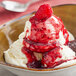 A bowl of ice cream topped with Oringer raspberry sauce.