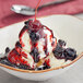 A bowl of ice cream with Oringer Wild Cherry topping.