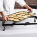 A chef using an American Metalcraft wrought iron griddle to cook pancakes.