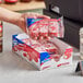 A hand holding a package of Hostess Zingers with red and white packaging.