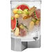 A Rosseto clear acrylic beverage dispenser with fruit and ice inside.