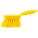 A yellow Carlisle Sparta pot scrub brush with a handle.