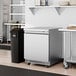 An Avantco ZUC-27R-HC stainless steel undercounter refrigerator in a kitchen.