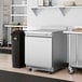 An Avantco stainless steel worktop refrigerator in a kitchen.