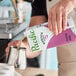 A carton of Pacific Foods Barista Series Hemp Milk being poured into a metal frothing pitcher.