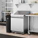An Avantco refrigerated sandwich prep table on a stainless steel counter.