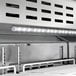 An Avantco VersaHub refrigerated sandwich prep table with a white cutting top.