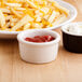 A bowl of french fries with cheese and ketchup on a plate.