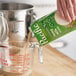 A carton of Pacific Foods Hemp Milk being poured into a glass measuring cup on a kitchen counter.