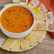 A bowl of soup with KEEBLER® crackers on a table.