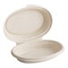 A close-up of a white oval-shaped World Centric compostable fiber container with a lid.