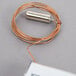 A copper coil with a cylindrical object on one end.