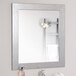 A BrandtWorks silver grain finish mirror on a wall above a white towel.