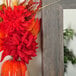 A BrandtWorks barnwood gray mirror with a vase of flowers and leaves in it.