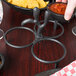 A person using an HS Inc. salsa caddy to hold molcajetes of salsa on a table.