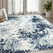 An Abani Arto Collection blue and white contemporary area rug with abstract designs on the floor.