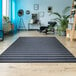 A Couristan Afuera Beachcomber runner rug in a room with wood floors, a blue chair, and a plant.