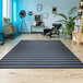 A Couristan Afuera Beachcomber Marine / Shell runner rug in a room with wood floors and a chair with a black and white blanket.