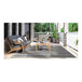 A table and chairs on a Couristan Tangent area rug on a porch.
