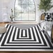 A cream and black modern geometric rectangle area rug.