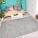 An ivory and coral Couristan Cape Falmouth area rug in a room with a couch and a table with food on a tray.