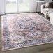 An Abani Lola Collection brown and blue vintage medallion area rug on a wood floor.