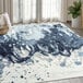 A blue and white Abani Arto Collection area rug with abstract designs on the floor.