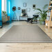 A Couristan Afuera Beachcomber runner rug on a wood floor with a chair and plant in the background.
