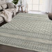 A cream and gray geometric lined Abani Cabo Collection area rug on the floor.