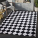 An Abani Parker Collection cream and black area rug with a diamond checkered pattern.