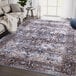 An Abani Lola brown and blue vintage floral medallion area rug in a room with a couch.