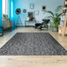 A Couristan Afuera Herringbone runner rug in a room with a chair and a shelf.