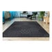 A Couristan Afuera Anode black and white rug with geometric patterns on a floor.