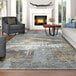 A living room with a Couristan Dreamscape gray area rug under a wood table near a fireplace.