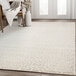 An Abani Arto Collection cream and beige cheetah print area rug in a room with white walls.