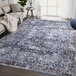 A blue and brown Abani Lola Collection area rug with a vintage design in a room.