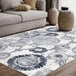 An Abani Arto Collection cream and blue area rug with a distressed medallion design.