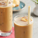 Two glasses of brown liquid with HAY! wheat straws.