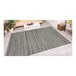 A Couristan Cape Hinsdale area rug with a gray and white pattern on the floor in a room.