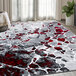 An Abani Arto Collection gray rug with red and black accents and a white pattern in a room with a white blanket.