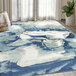 An Abani Arto Collection cream and blue area rug with abstract designs on the floor in a room.